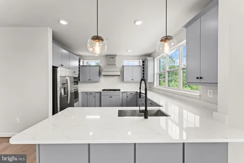a large kitchen with kitchen island a large counter space a sink appliances and a window