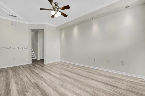 a view of a hallway with wooden floor and entryway