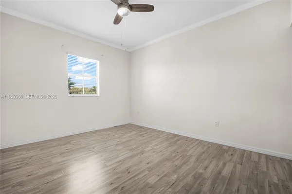 a view of an empty room with wooden floor