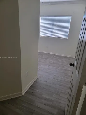 an empty room with wooden floor and a window