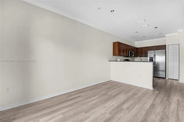 a kitchen with kitchen island granite countertop stainless steel appliances a sink a stove cabinets and a refrigerator