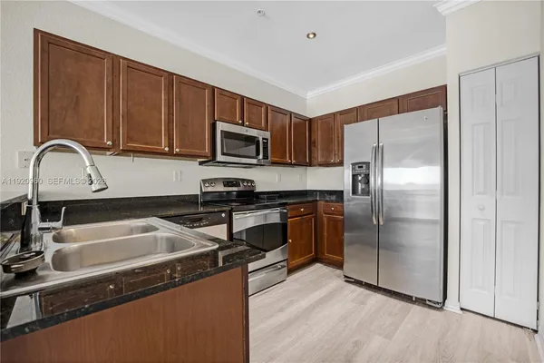 a kitchen with stainless steel appliances granite countertop a refrigerator and a sink