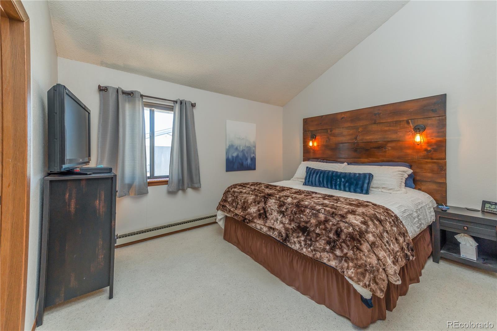 317 County Road 832, Unit 2412 Fraser, CO 80442 - Photo 8 of 17 a bedroom with a bed and a flat tv screen on dresser