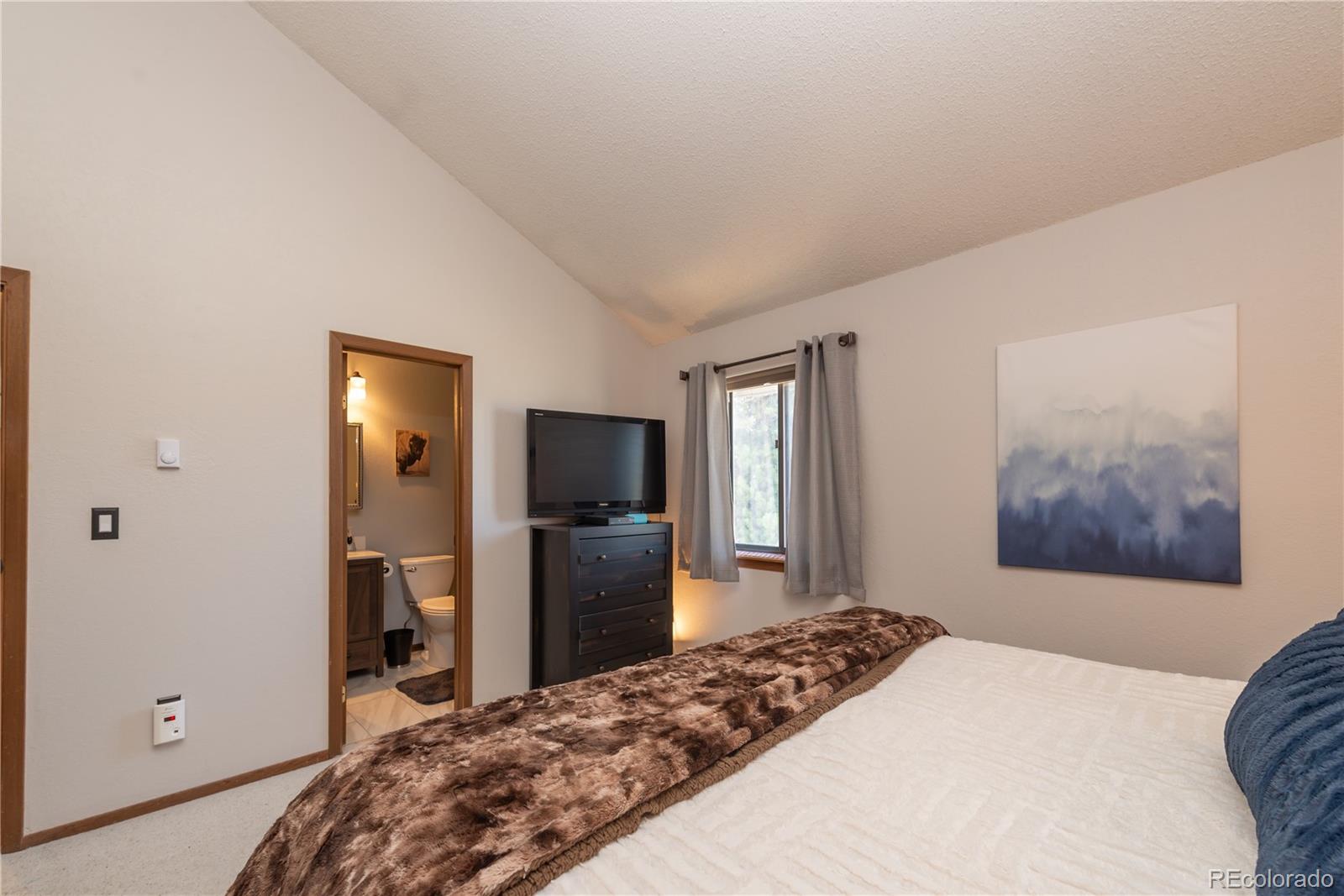 317 County Road 832, Unit 2412 Fraser, CO 80442 - Photo 9 of 17 a bedroom with a bed and a flat screen tv