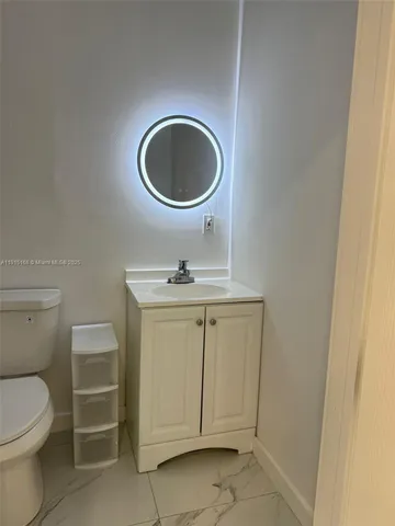 a bathroom with a toilet a sink and a mirror