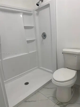 a bathroom with a toilet and a shower