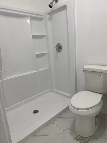 a bathroom with a toilet and a shower