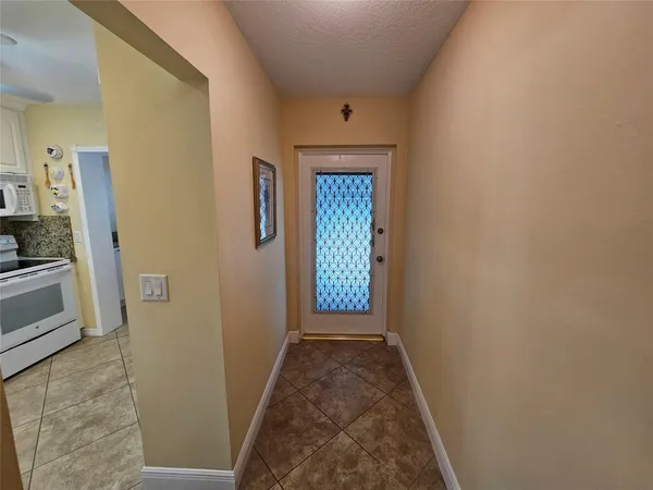 a view of a hallway with wooden floor and a living room