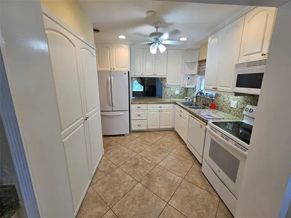 a large kitchen with a sink stainless steel appliances and cabinets