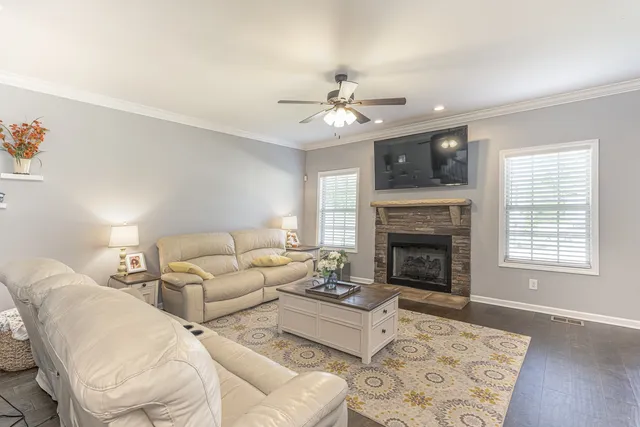 a living room with couches a fireplace and a flat screen tv