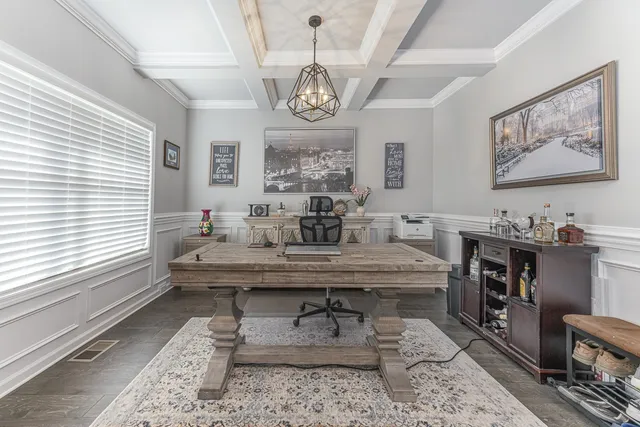 a dining room with wooden floor a chandelier a wooden table and chairs