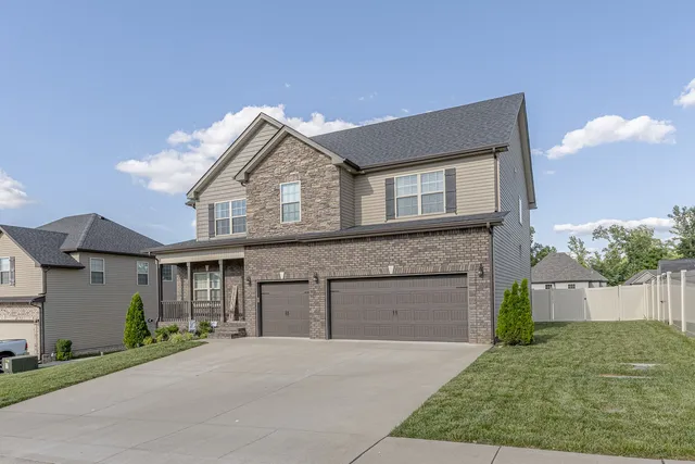 a front view of a house with a garden and garage
