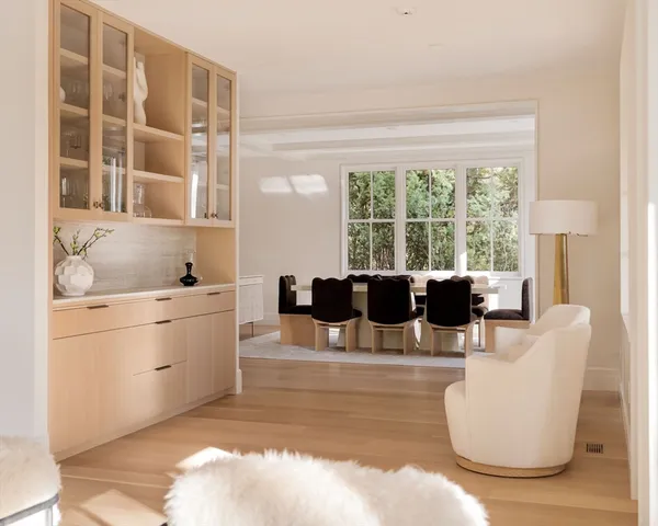 a living room with furniture a large window and kitchen view