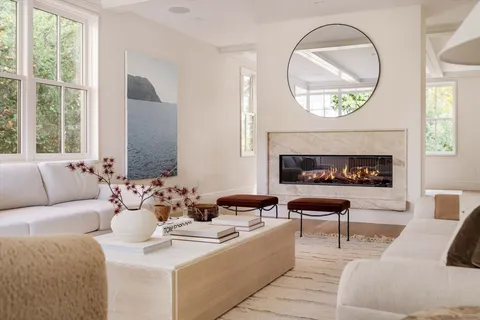 a living room with furniture a large window and a fireplace