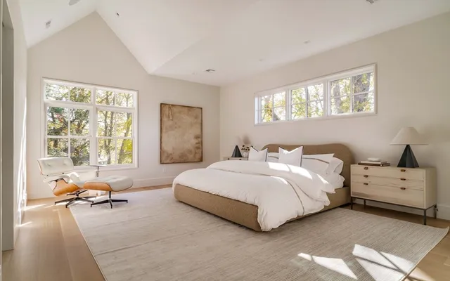 a spacious bedroom with a bed and glass window