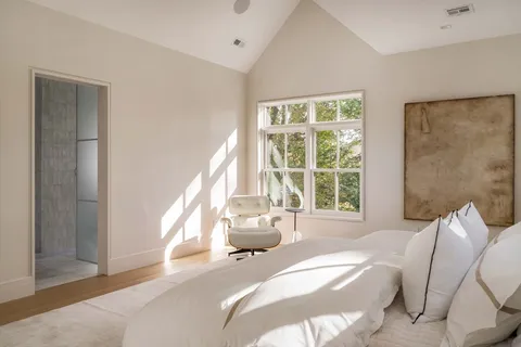 a spacious bedroom with a bed and a large window
