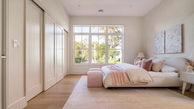 a bedroom with a bed lamp and a large window