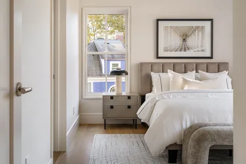 a bedroom with a bed and a painting on the wall