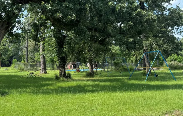 a grassy field with a trees