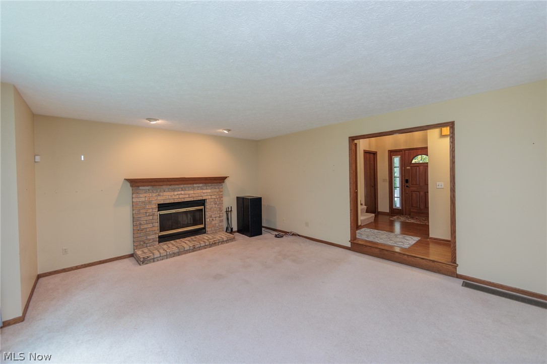 4123 Baird Road Stow, OH 44224 - Photo 6 of 47 Unfurnished living room featuring a textured ceiling, carpet floors, and a fireplace