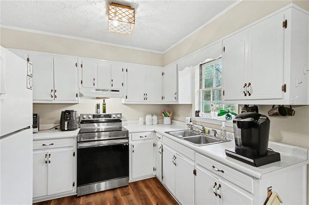 845 Idlewood Road Winder, GA 30680 - Photo 11 of 25 a kitchen with cabinets appliances a sink and a window