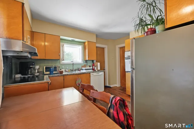 a kitchen with stainless steel appliances granite countertop a refrigerator and a stove top oven