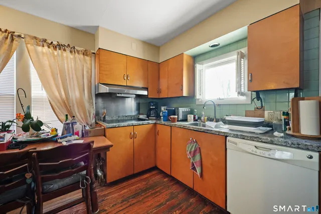 a kitchen with stainless steel appliances granite countertop sink stove top oven and cabinets