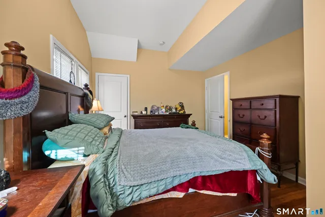 a bedroom with a bed a dresser and a painting on the wall