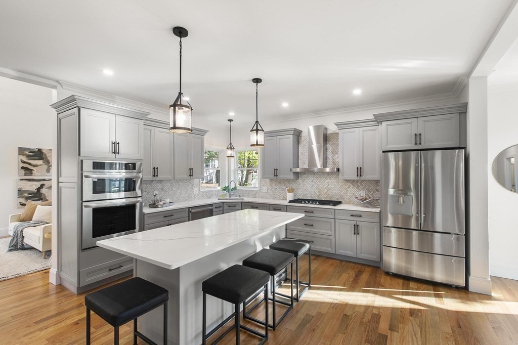 50 Azalea Circle Reading, MA 01867 - Photo 3 of 41 a kitchen with stainless steel appliances granite countertop a stove refrigerator and cabinets