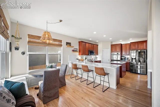 a living room with stainless steel appliances kitchen island granite countertop a dining table chairs and a living room view