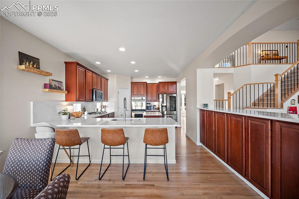 9393 St.George Road Peyton, CO 80831 - Photo 17 of 49 a kitchen with a dining table chairs stove and white cabinets