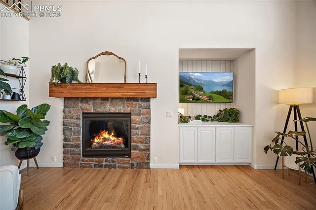 a living room with a fireplace with potted plants
