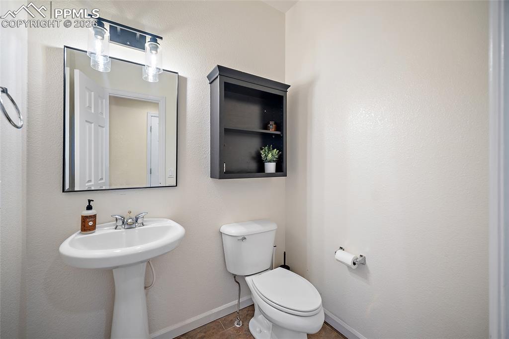 9393 St.George Road Peyton, CO 80831 - Photo 23 of 49 a bathroom with a toilet sink and mirror