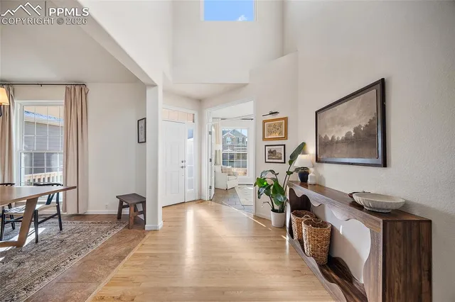 a living room with furniture a wooden floor and next to a window