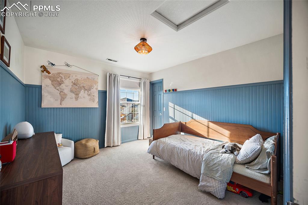 9393 St.George Road Peyton, CO 80831 - Photo 35 of 49 a bedroom with bed and a chandelier