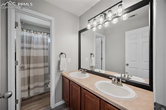 a bathroom with a granite countertop sink a mirror and a shower