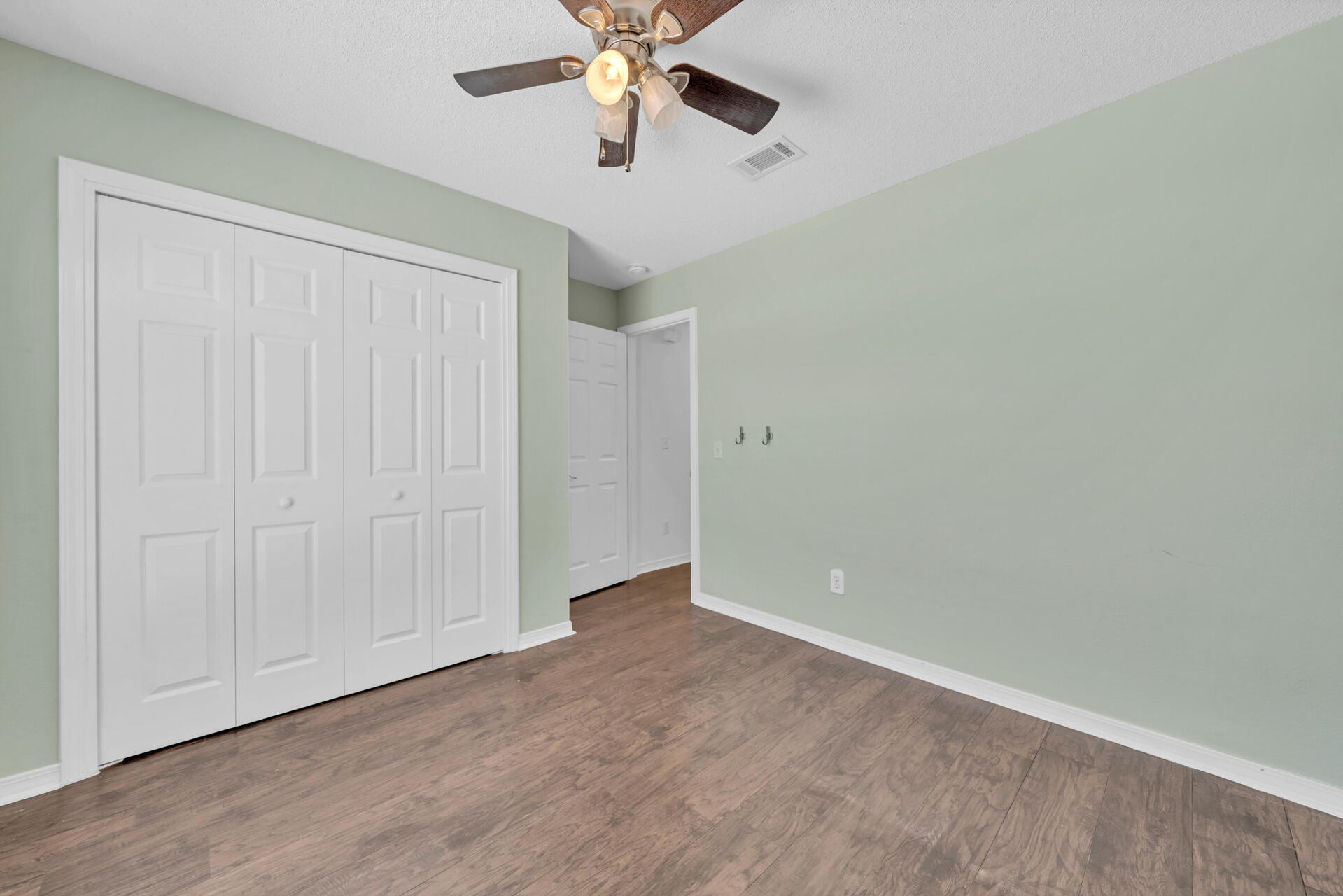 84 Vicki Street Santa Rosa Beach, FL 32459 - Photo 11 of 39 an empty room with a chandelier fan and windows
