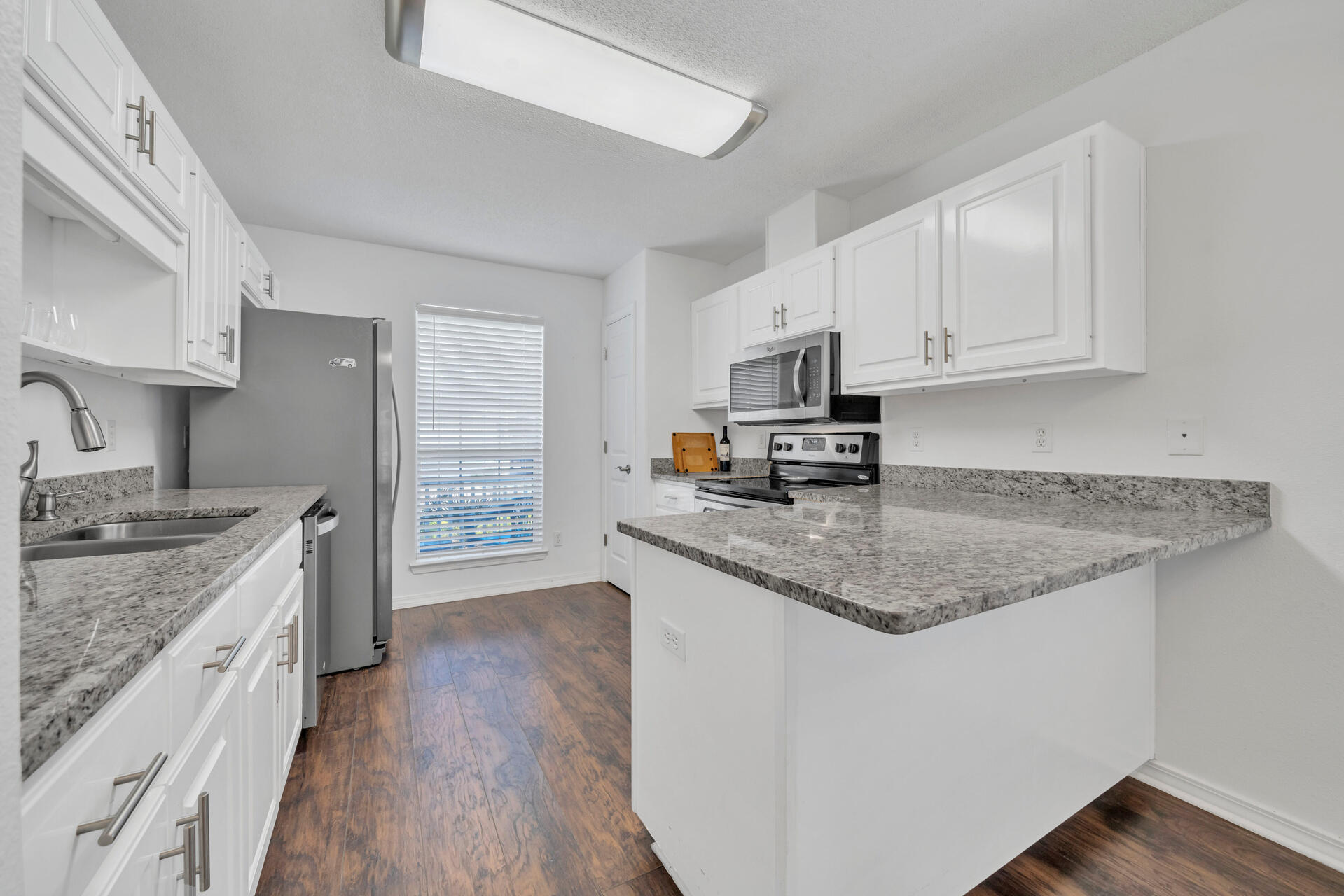 84 Vicki Street Santa Rosa Beach, FL 32459 - Photo 15 of 39 a kitchen with stainless steel appliances granite countertop a stove a sink dishwasher and a refrigerator with white cabinets