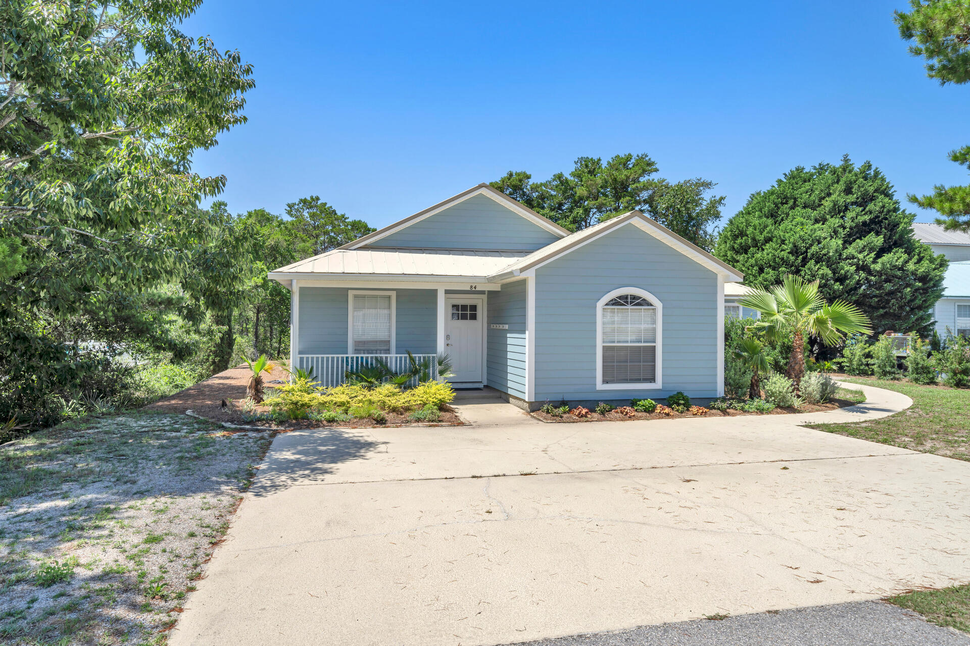 84 Vicki Street Santa Rosa Beach, FL 32459 - Photo 3 of 39 a front view of a house with a yard and potted plants