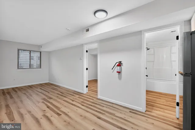 an empty room with wooden floor and closet