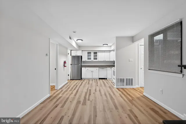 a view of a bedroom with wooden floor and a window