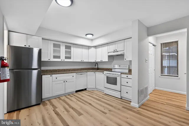 a kitchen with stainless steel appliances granite countertop a refrigerator sink and stove