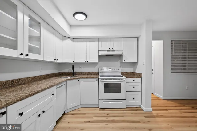a kitchen with stainless steel appliances granite countertop a sink and a stove