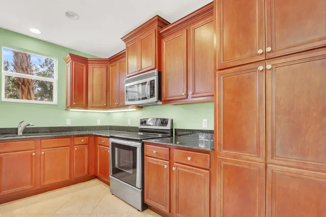 a kitchen with stainless steel appliances granite countertop cabinets and a sink