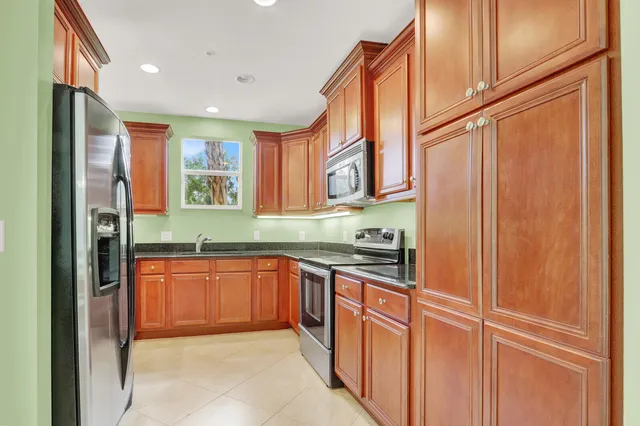 a kitchen with stainless steel appliances granite countertop cabinets and a refrigerator