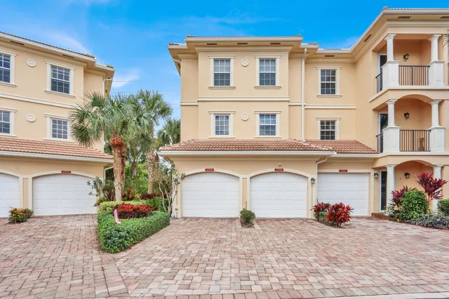 a view of a building with a yard and a garage