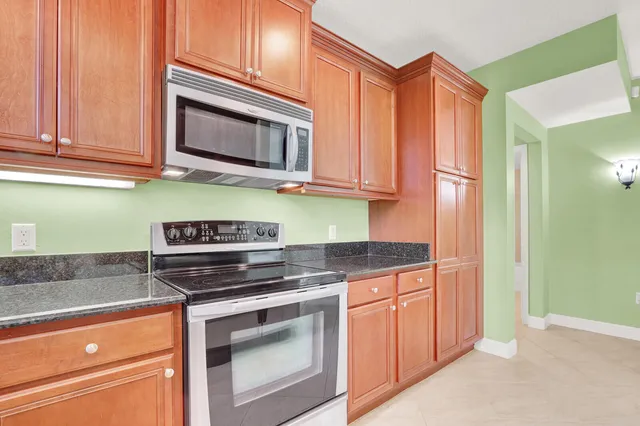 a kitchen with granite countertop cabinets stainless steel appliances and a counter space