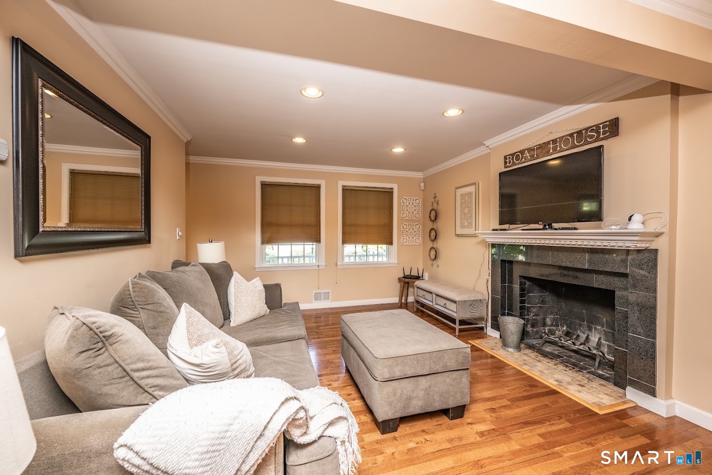 144 Goff Road Wethersfield, CT 06109 - Photo 9 of 26 Inviting living room featuring hardwood floors, recessed lighting, crown molding, and a wood-burning fireplace that adds warmth and character.