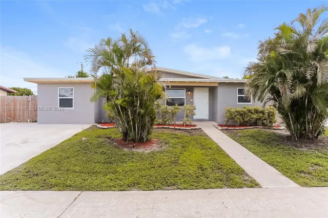 a picture of a house with a yard and potted plants