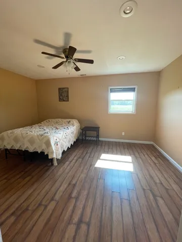 a bedroom with bed and wooden floor